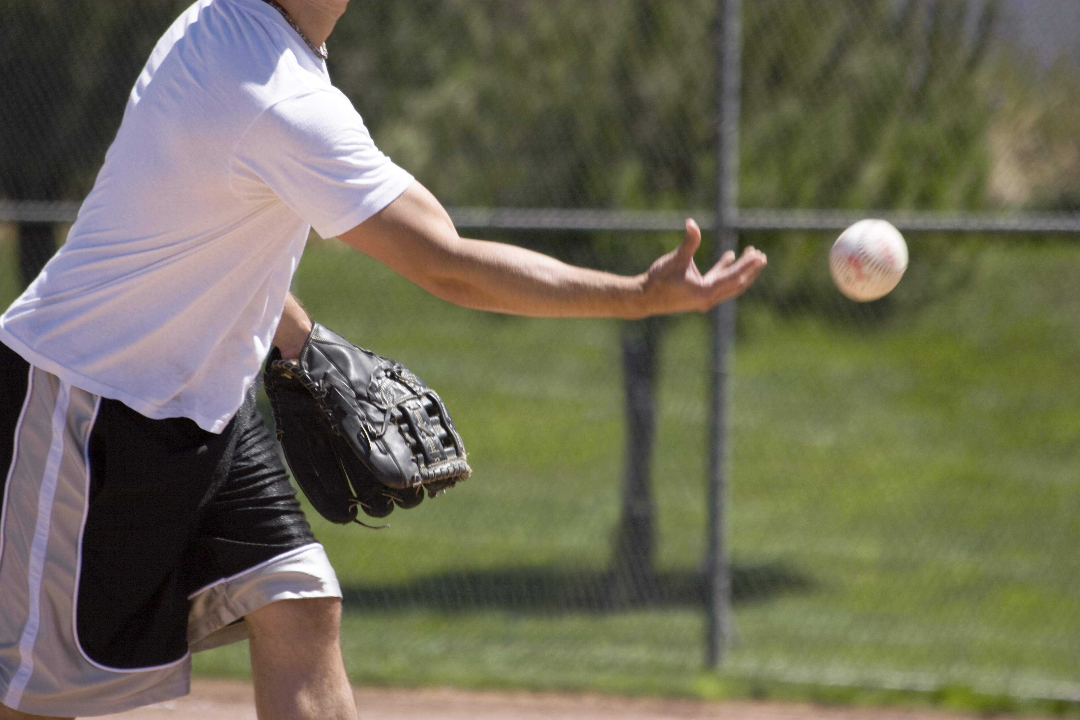 A man throws an underhand softball pitch