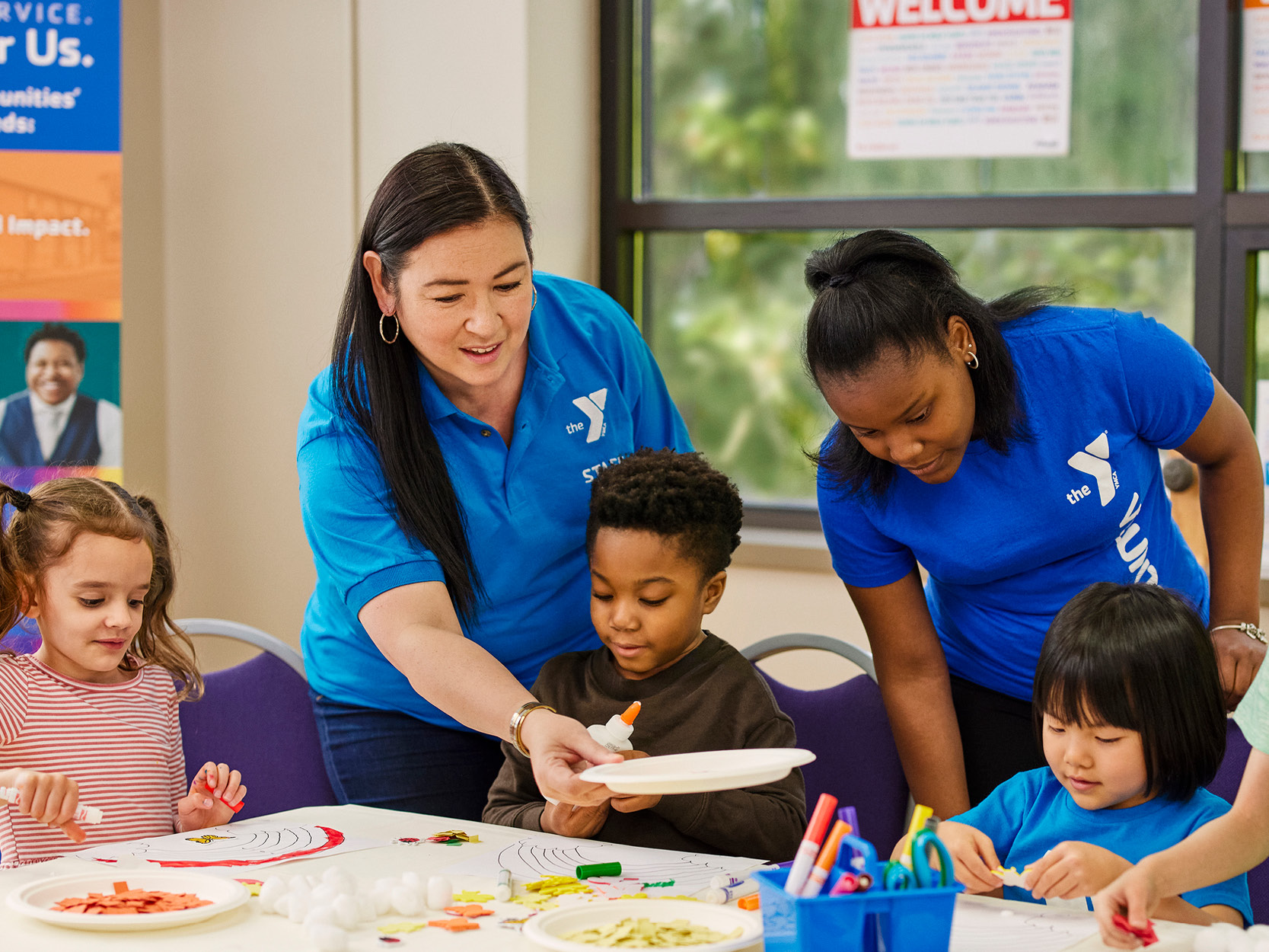 Child care staff with kids doing crafts