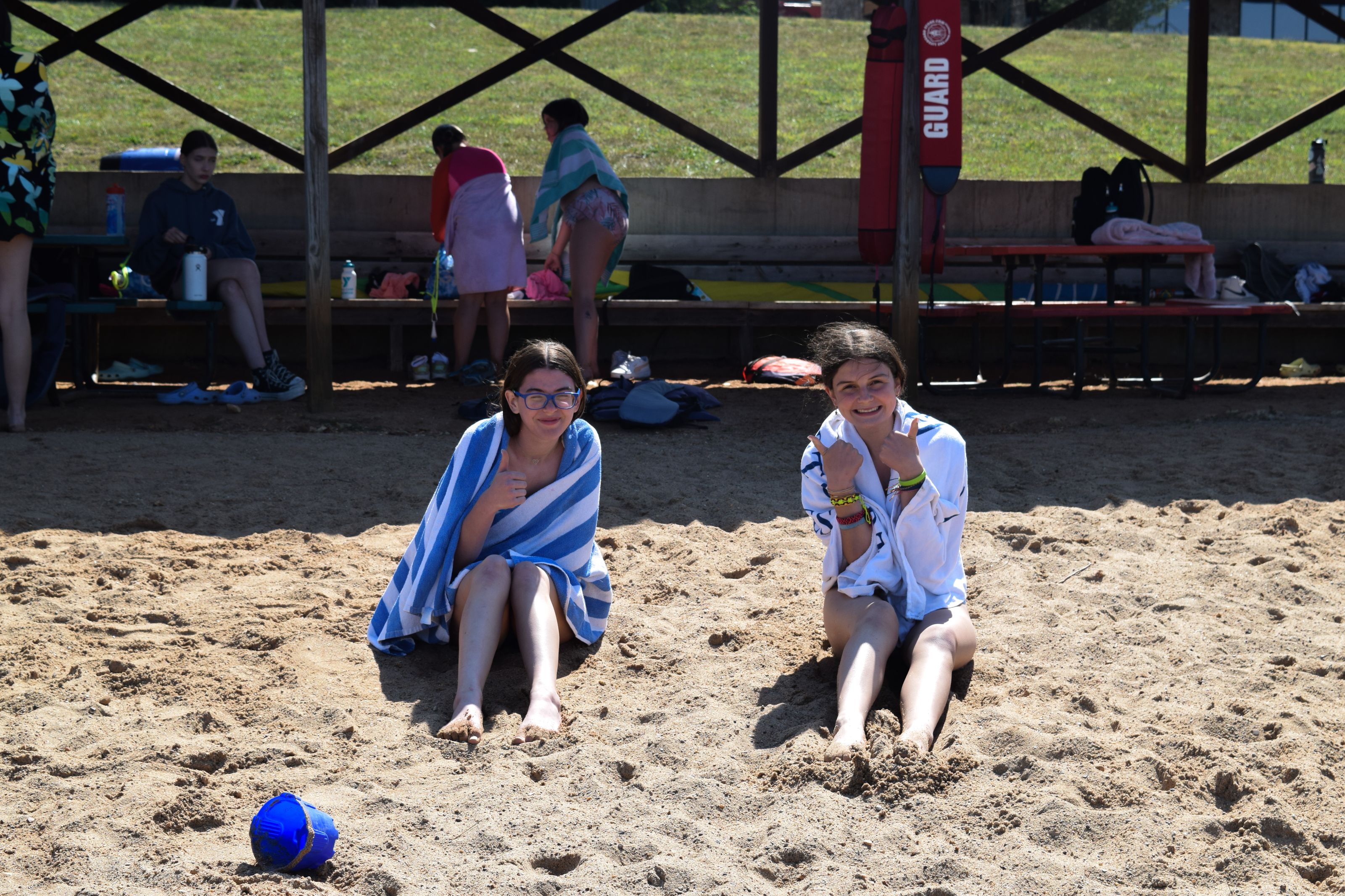 two ymca camp lakewood campers sitting on shore of lake