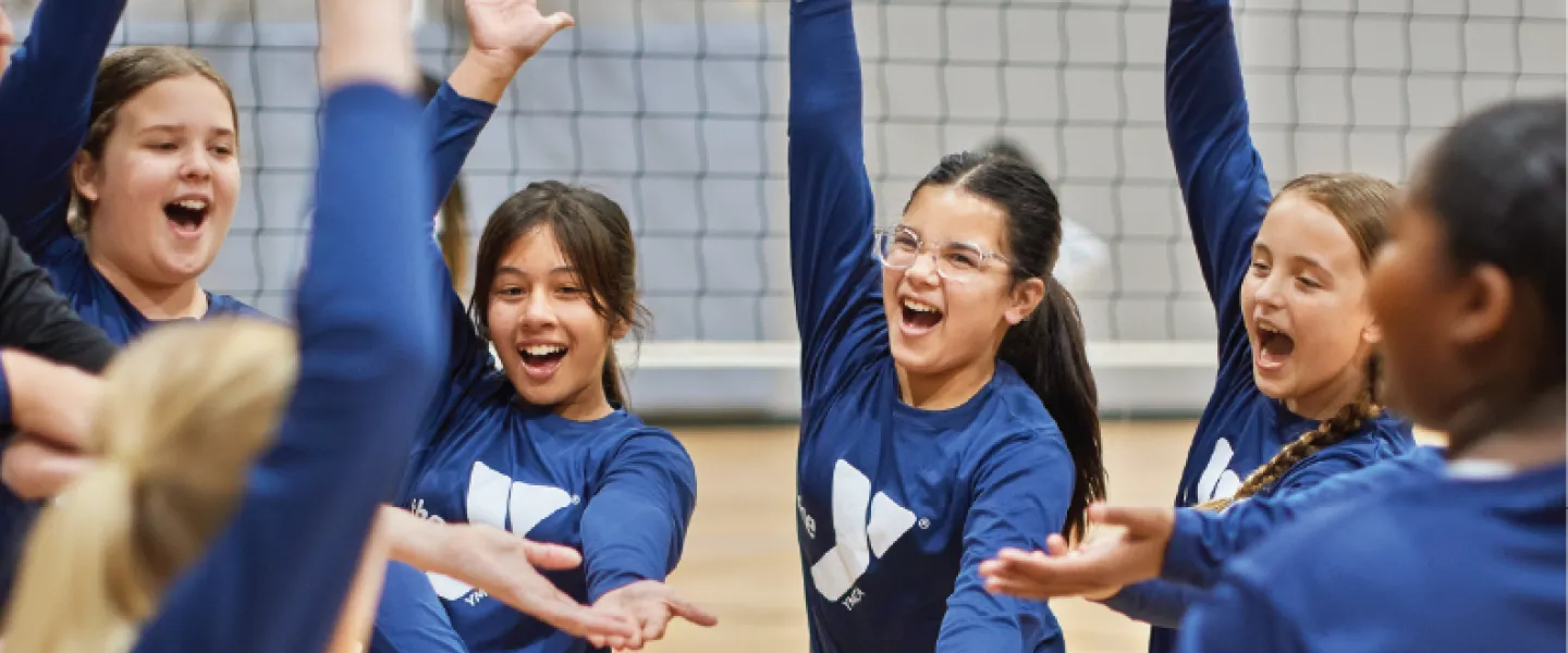ymca youth volleyball team cheering during a volleyball game