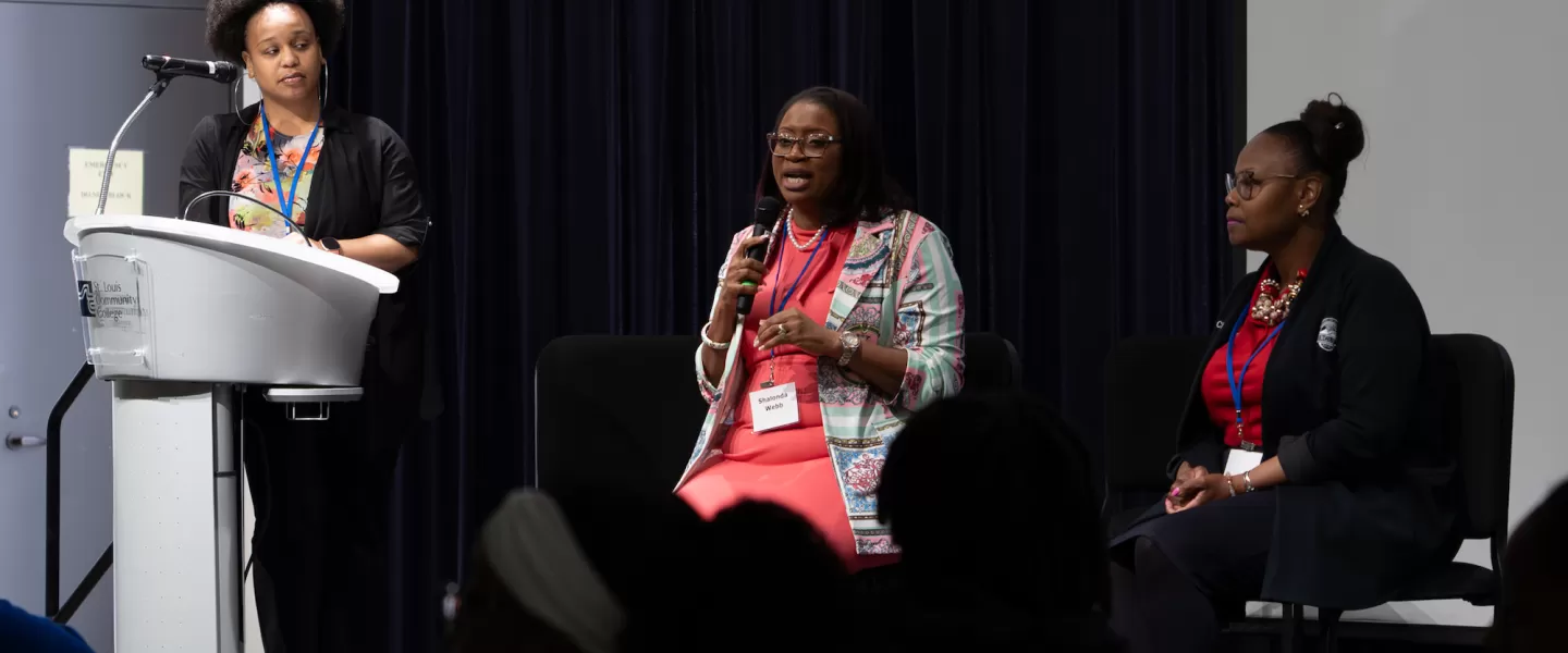 Keynote Speaker Addressing Students – A guest speaker, possibly a government official or legal professional, stands at the front of the room, delivering remarks to an audience of engaged students.