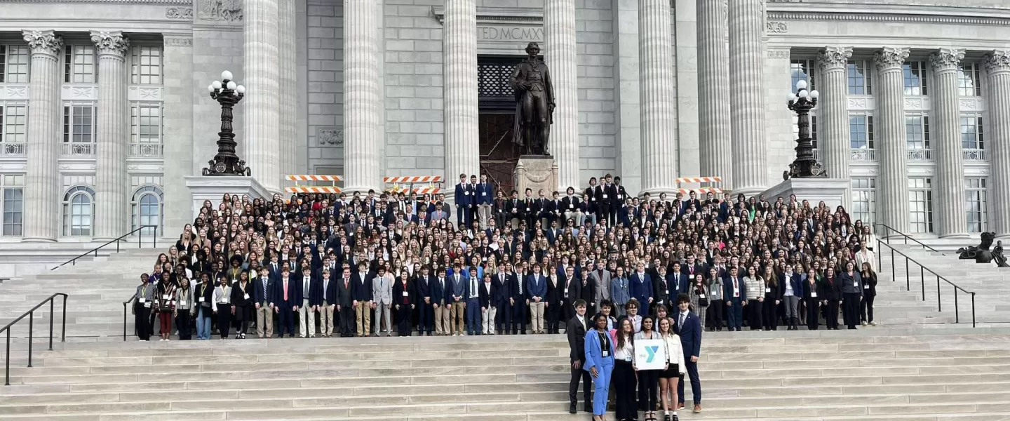 Group Photo of Participants – A large group of students, law school mentors, and YMCA staff poses together at the end of the conference, smiling in front of a backdrop featuring the Gateway Region YMCA and St. Louis University Law School logos.