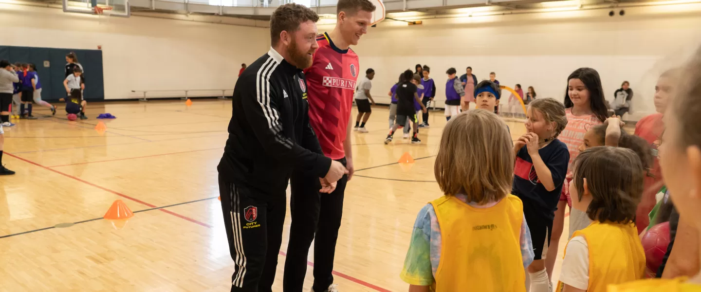St. Louis CITY SC Defender, Joakim Nilsson, and YMCA Soccer Coach interacts with YMCA youth, offering tips and encouragement during soccer drills at the kickoff event.
