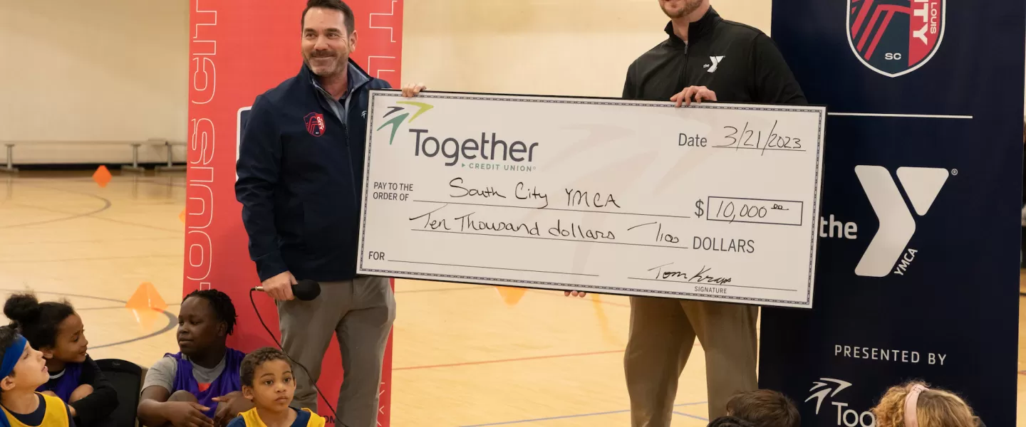 YMCA District Vice President Matt Thompson and St. Louis CITY SC staff hold a $10,000 donation check from Together Credit Union, supporting youth soccer programs in partnership with the Gateway Region YMCA.