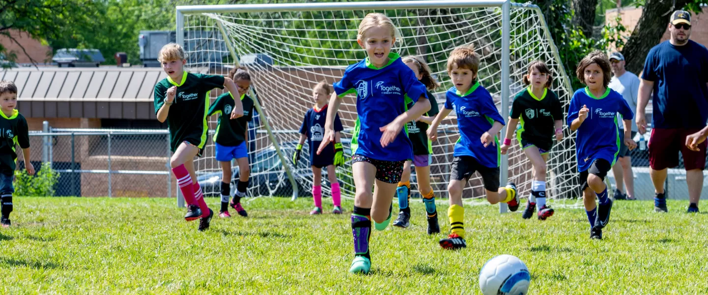Young soccer players compete in a friendly match wearing newly branded CITY SC and Gateway Region YMCA jerseys.