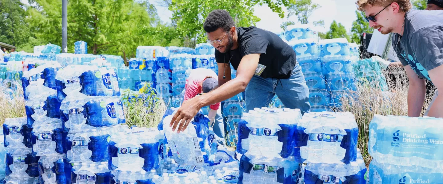 YMCA tornado relief volunteer organizing cases of bottled water from a supply truck at O'Fallon Park Rec Complex