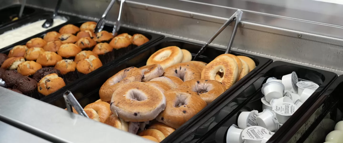 Morning buffet featuring bagels, muffins, and assorted breakfast pastries