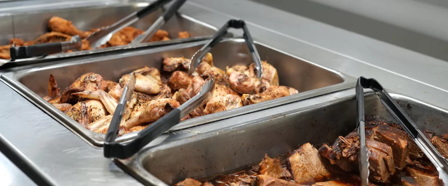 Dinner buffet featuring sliced brisket and roasted chicken breasts with sides