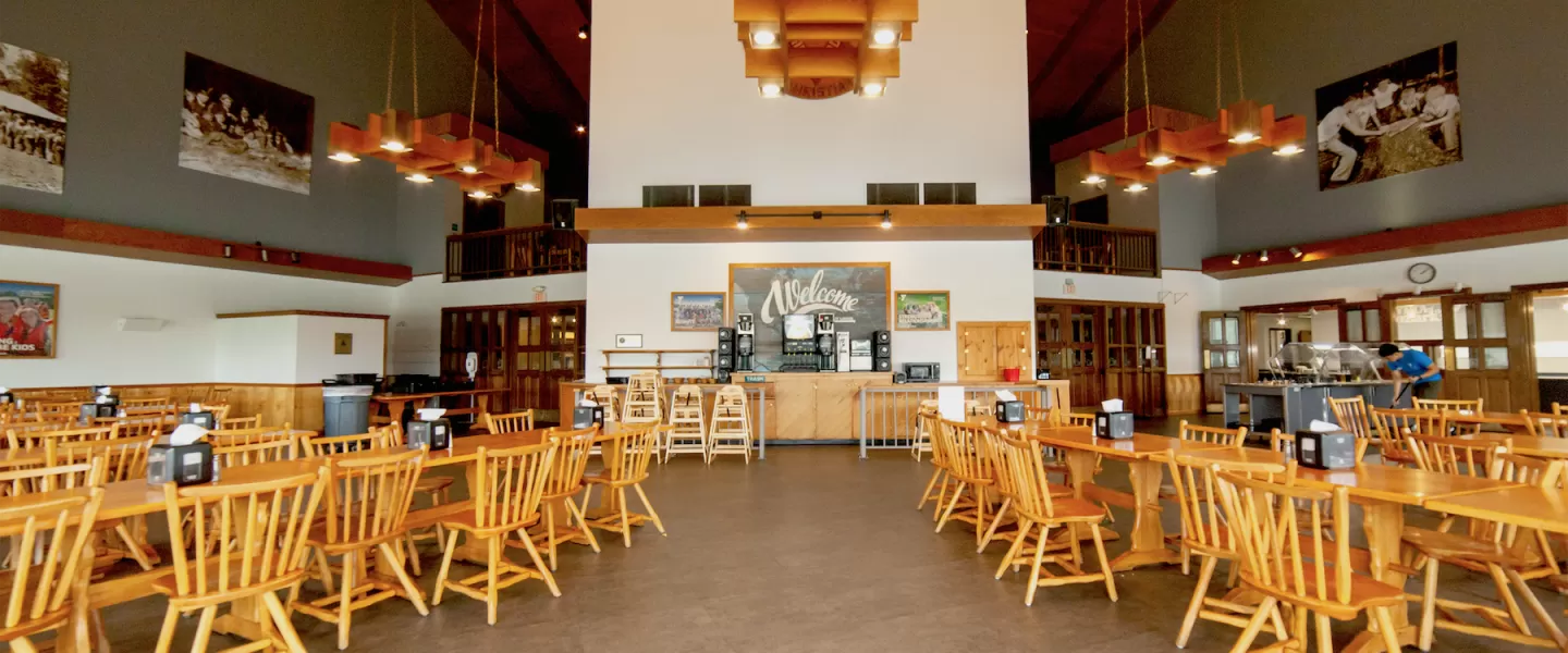 Family-style dining tables arranged in the Trout Lodge Dining Hall overlooking Sunnen Lake
