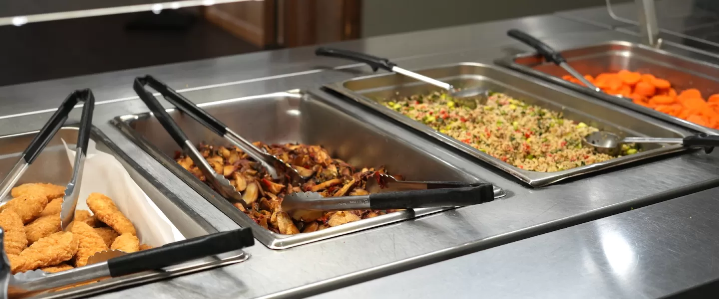 Hot jambalaya dish served buffet-style with sausage, rice, and vegetables