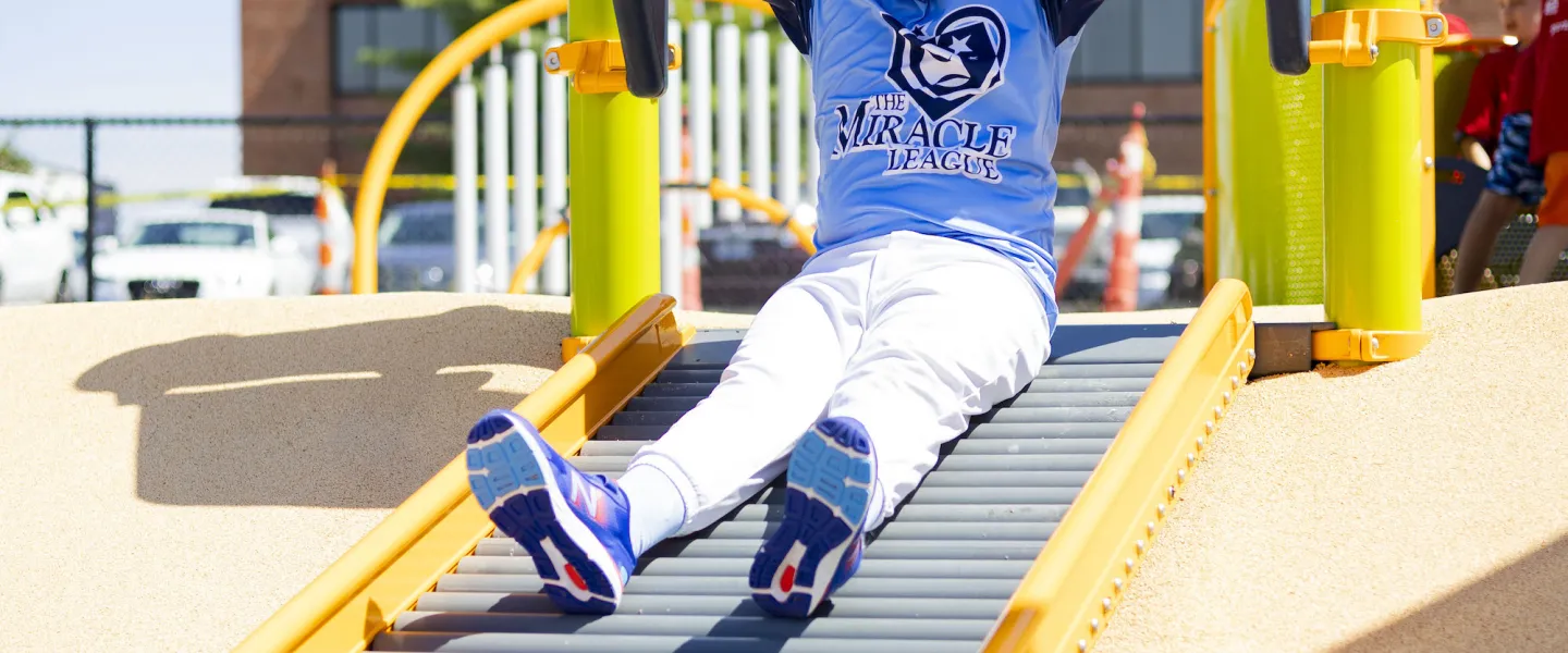 A young athlete goes down the slide at the South County YMCA's Adaptive Sports Complex Adaptive Playground