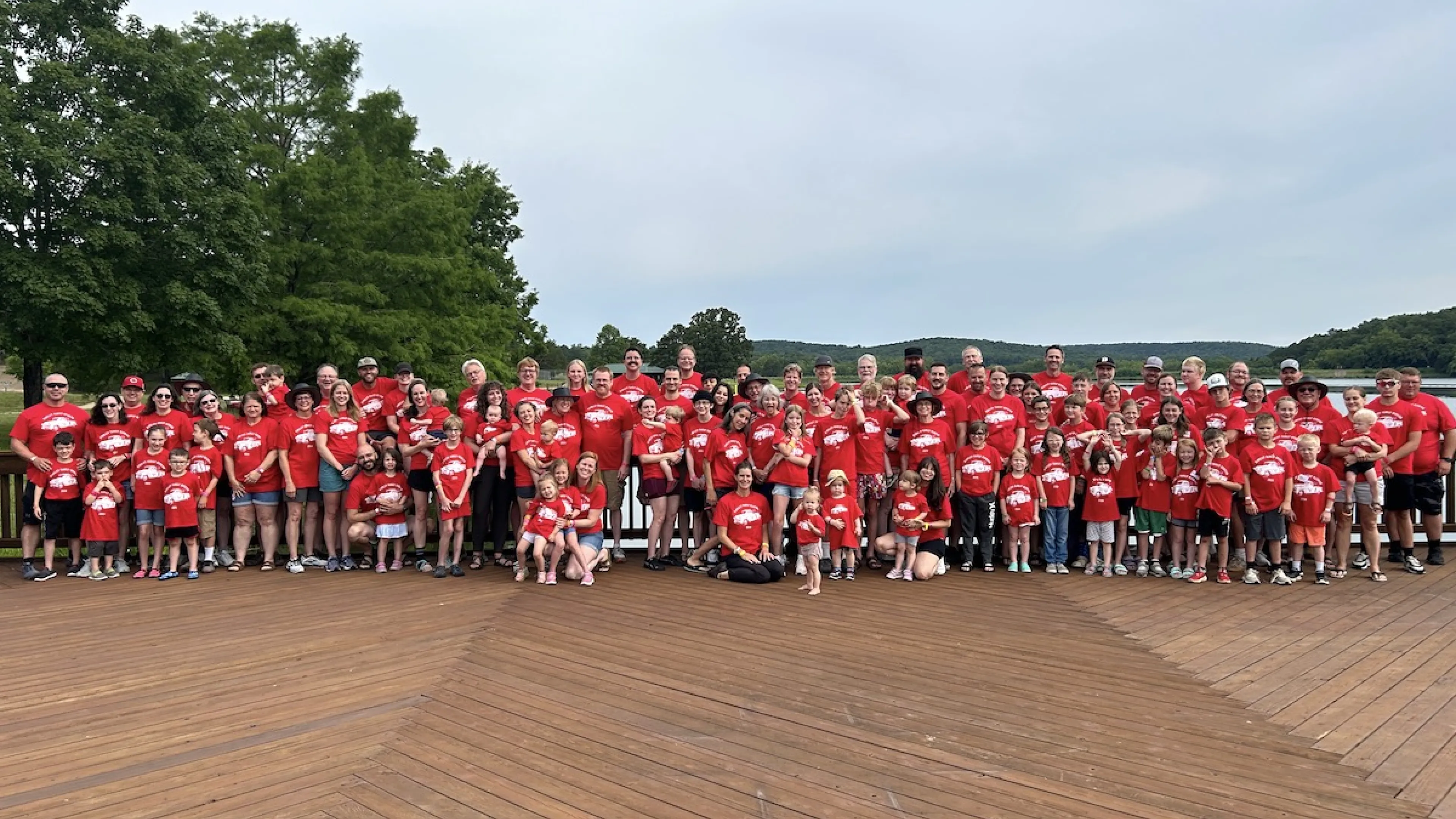 Family reunion posing for a group photo on the Trout Lodge deck in front of Sunnen Lake