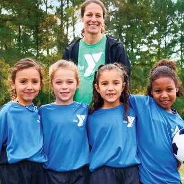 young girl ymca soccer players line up by the soccer goal for a picture