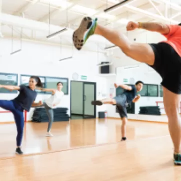 A group of people take a ymca kickboxing class.