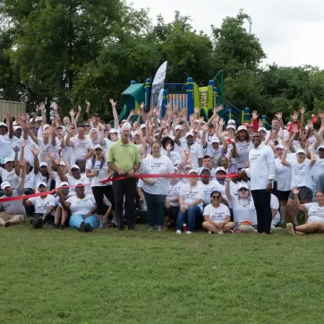 a group of volunteers cheering in front of a playground