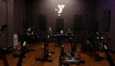 Thumbnail: Dark painted walls with mood lighting. Spin bikes placed throughout room.