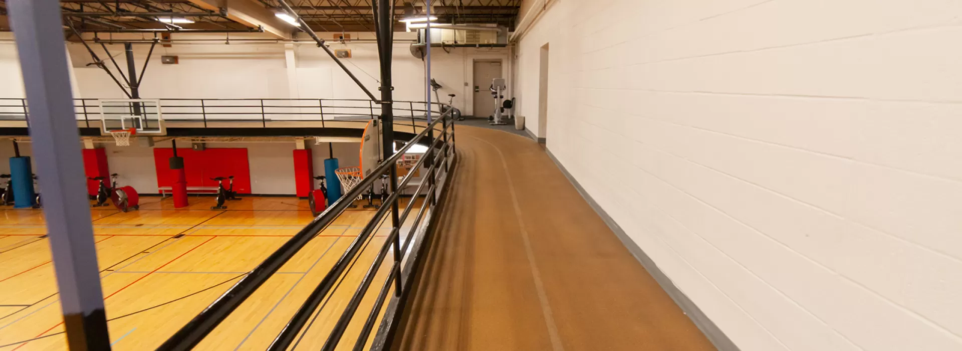 Indoor track running above gymnasium. Two-person wide path around the perimeter of gym