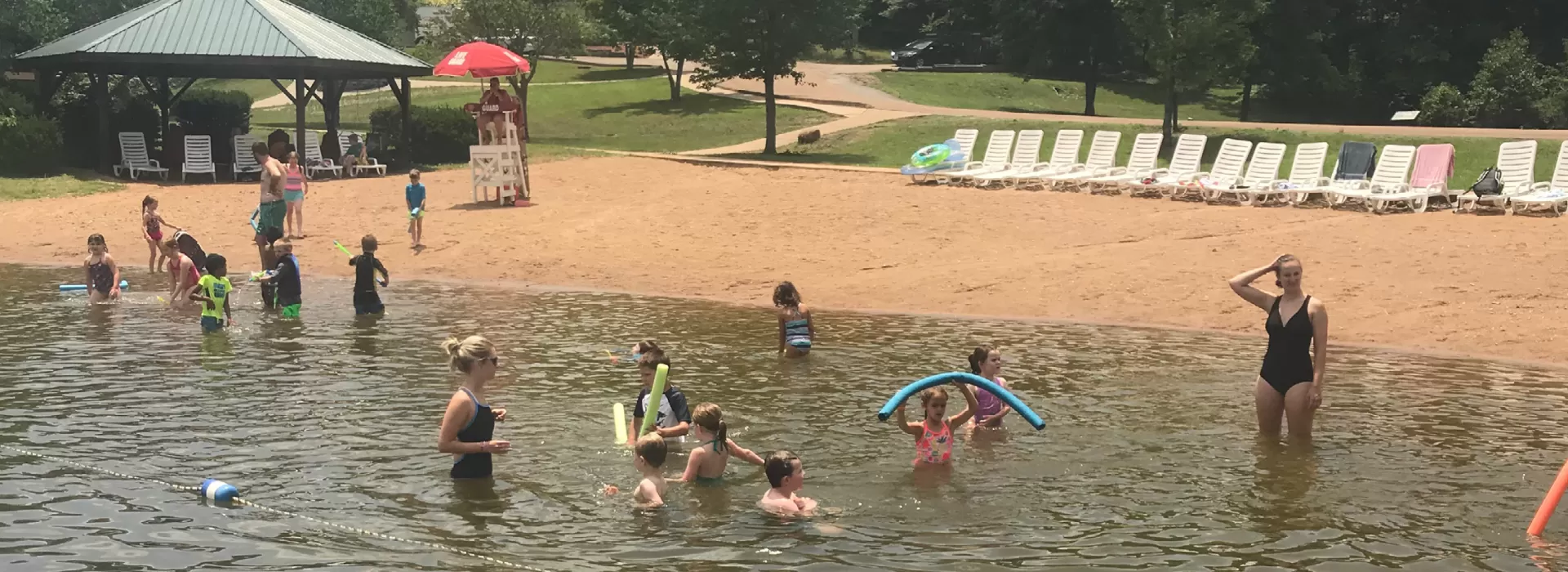 Families playing in the lake by the sandy beach
